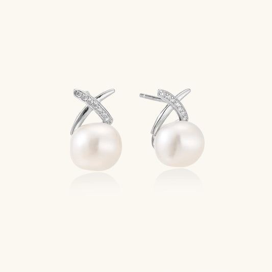 Rhodium-plated silver stud earrings with sparkling X design above lustrous round freshwater pearls on white background.