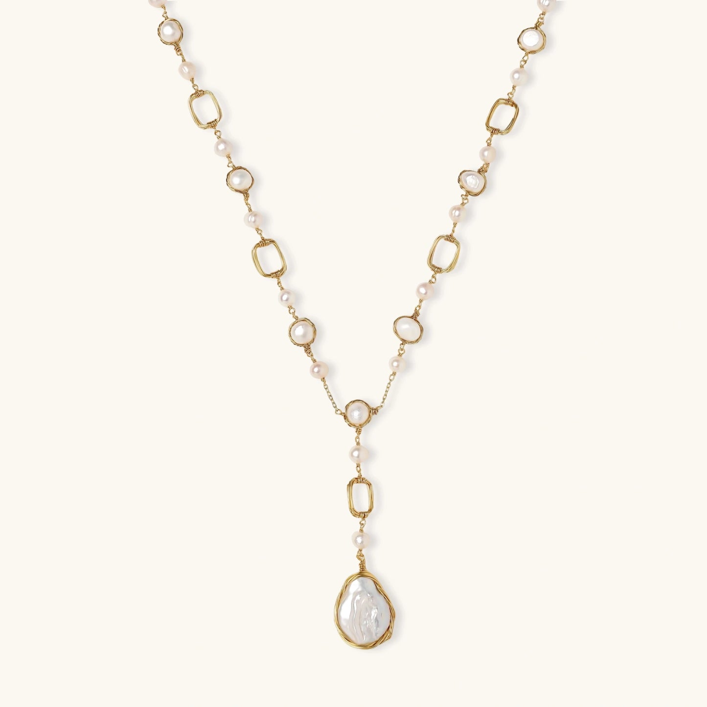 Long gold-plated necklace with alternating freshwater pearls and crystal bezels, featuring a large baroque pearl pendant