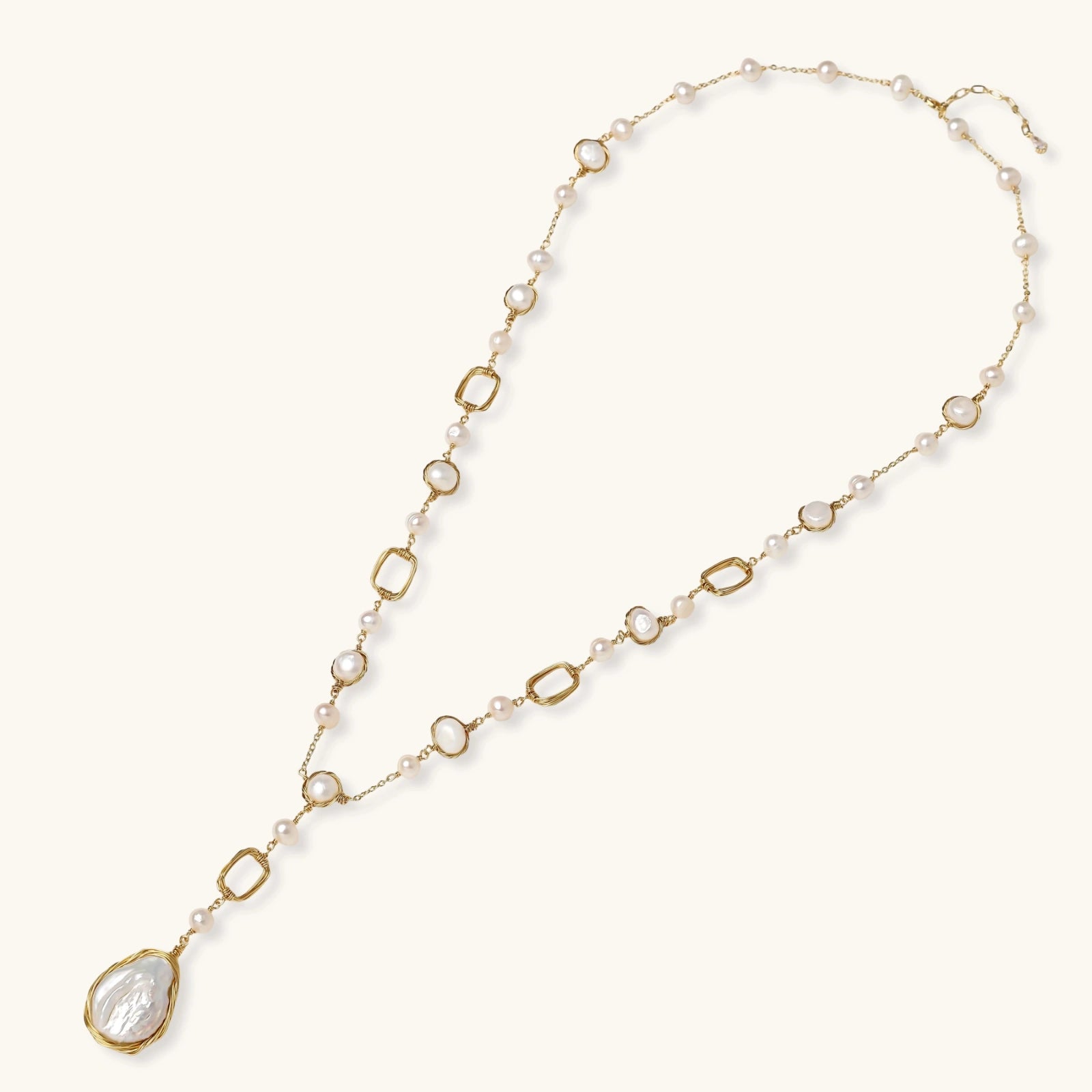 Long gold-plated necklace with alternating freshwater pearls and crystal bezels, featuring a large baroque pearl pendant